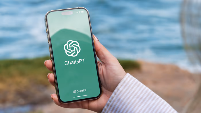 Người cầm điện thoại có logo ChatGPT